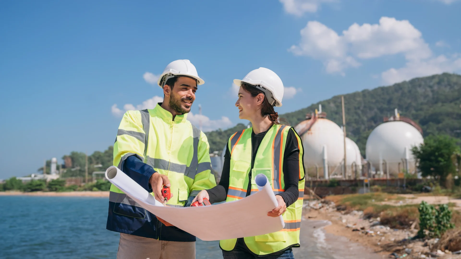 Two Engineers In Safety Gear With Blueprints Discu 2024 02 09 15 31 49 Utc